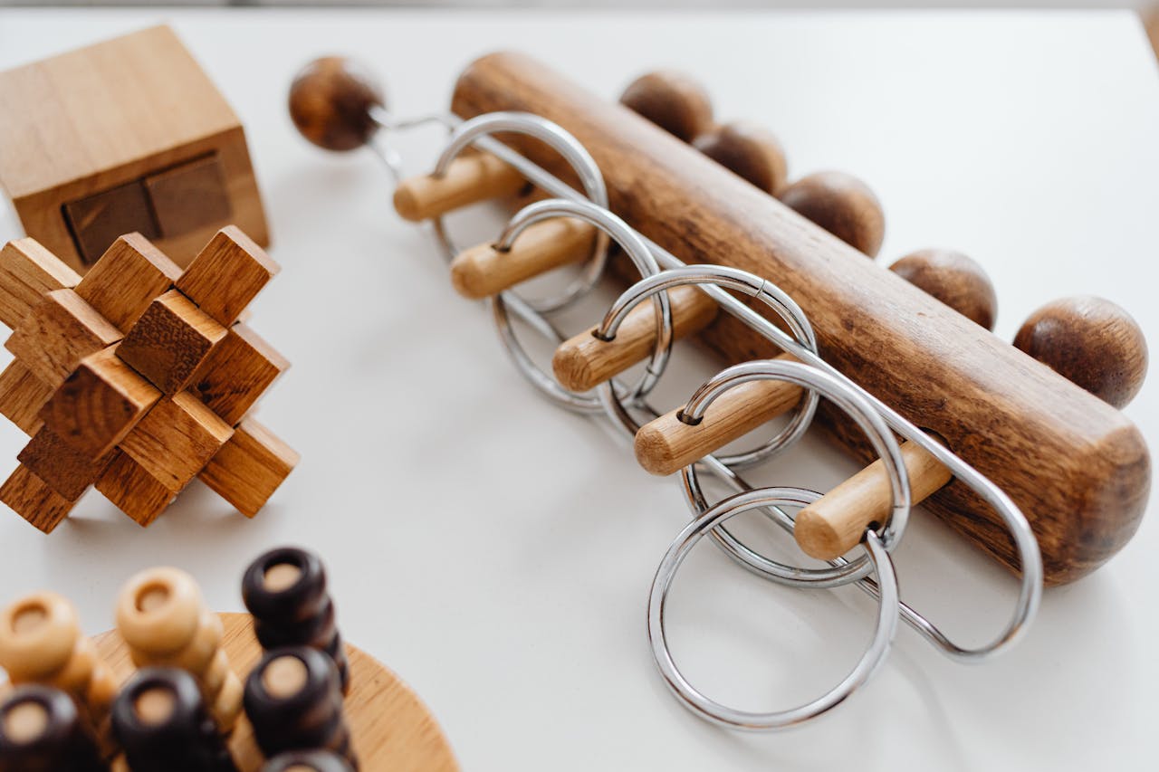 Intricate wooden puzzles and ring brain teasers on a table for cognitive challenge.