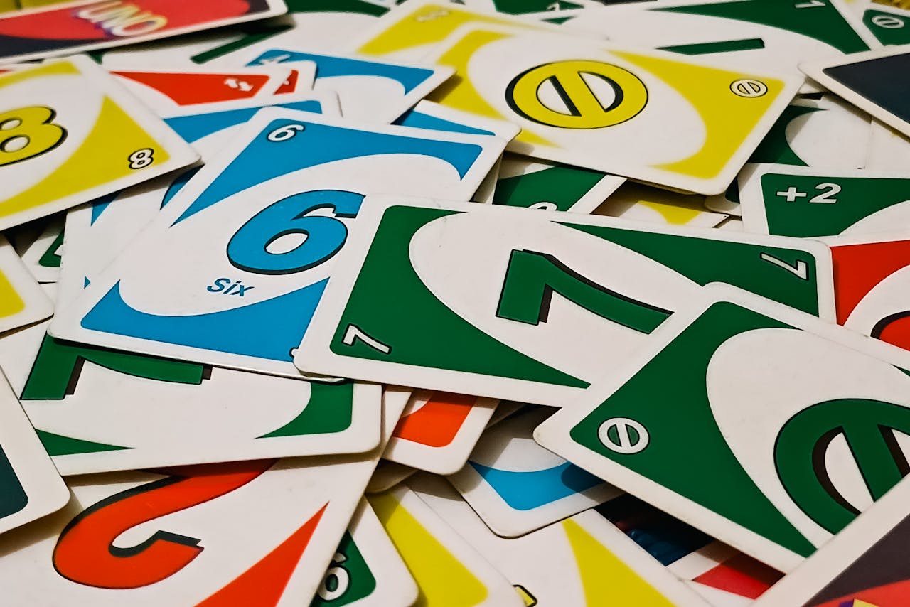 A vibrant display of Uno cards scattered in a random pile, showcasing various numbers and colors.